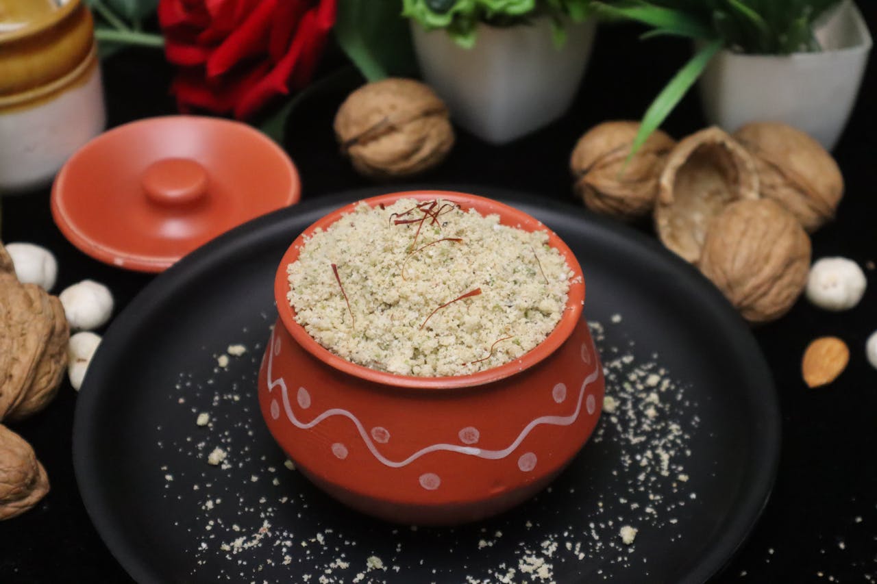 Homemade herbal powder with walnuts, saffron, and almonds in a traditional earthen pot.